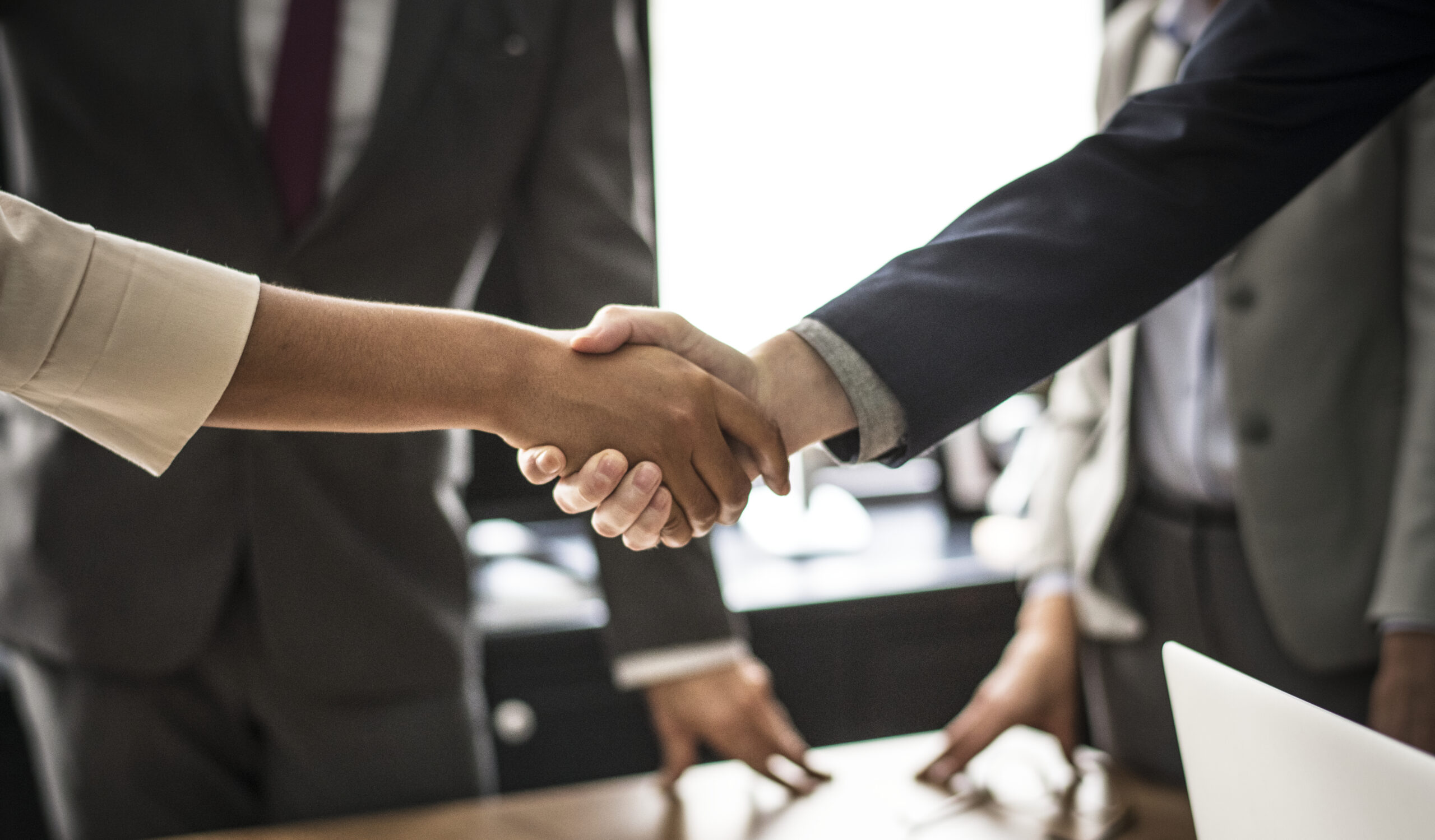 business people shaking hands meeting room scaled
